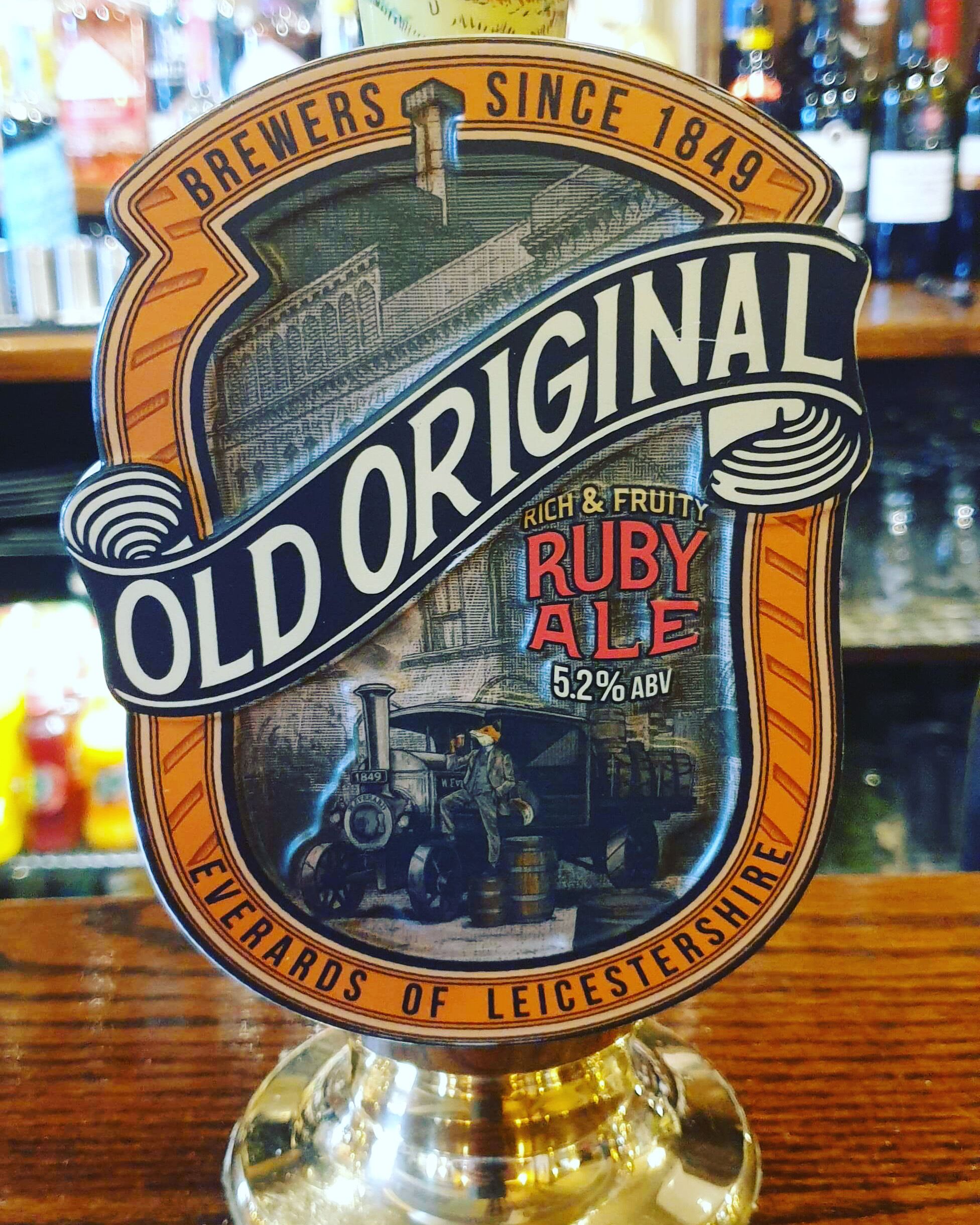 A beer tap labeled "Old Original Ruby Ale" with a vintage design and a steam engine illustration.