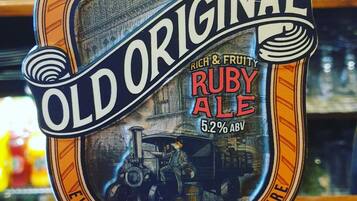 A beer tap labeled "Old Original Ruby Ale" with a vintage design and a steam engine illustration.