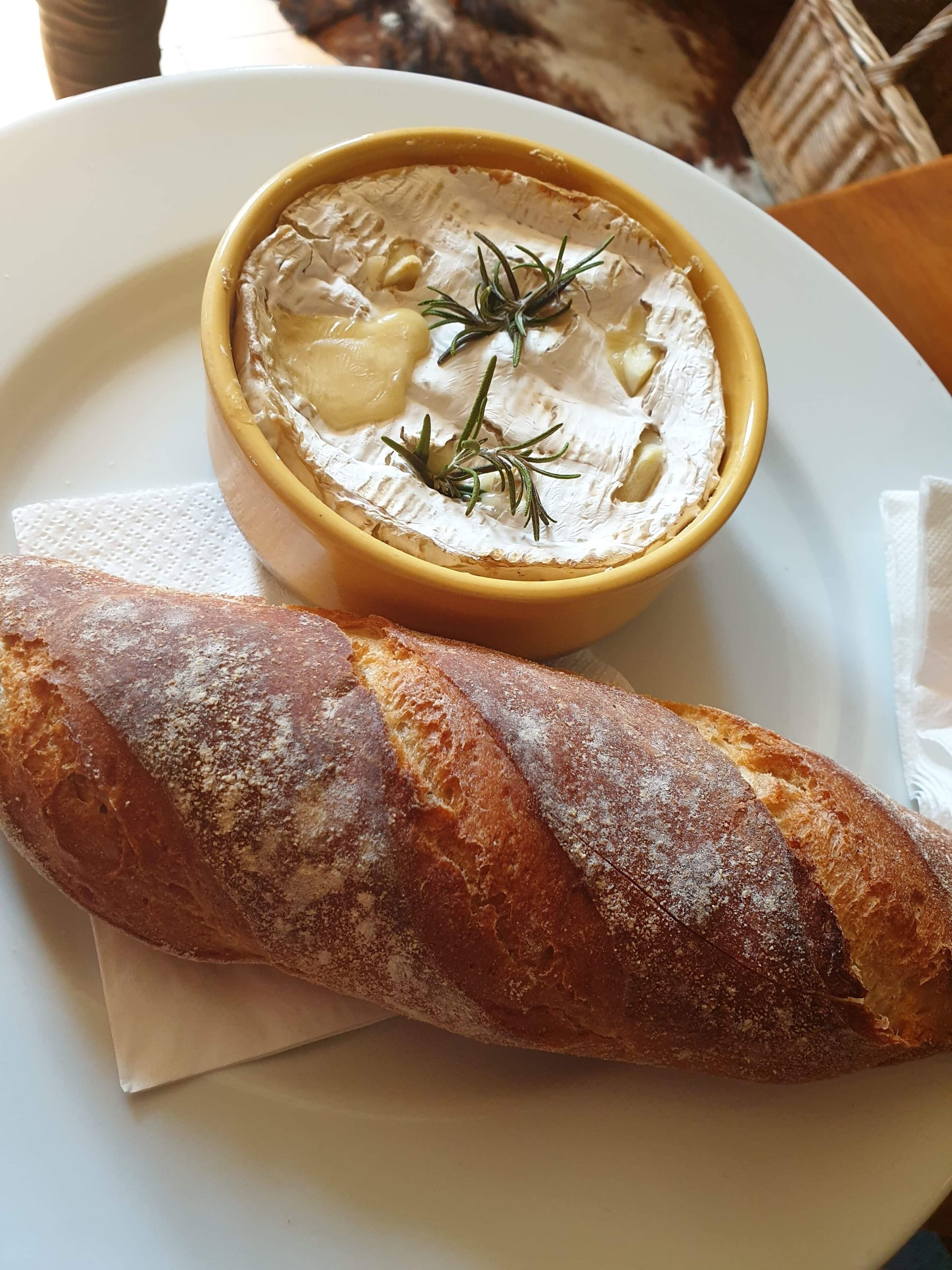 Lautasella on viipale leipää ja kulhossa juustoa.