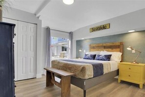 Relax in this serene bedroom with a large bed, bedside table, and comfortable bench.