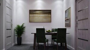 Uma sala de conferências com uma mesa, cadeiras, um vaso de plantas e obras de arte nas paredes.