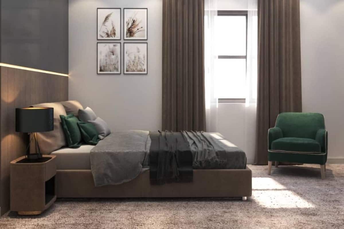 A modern bedroom with a bed, a nightstand, a green armchair, and a window with curtains.