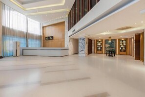 A spacious lobby with a reception desk, a seating area, and a large window with curtains. - City Comfort Inn Wuhan Fengshu Er Road Baijin Mansion (Wuhan)