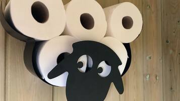 A top-down view of a wooden floor with several rolls of toilet paper arranged in a cluster.