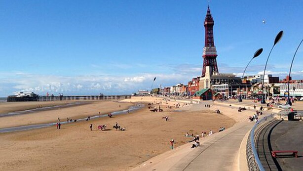A beach with a prominent tower, a pier extending into the water, and a promenade with people. - The Shippon -hot Tub ext chg - Superking-log Fire (Preston)