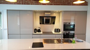 A modern kitchen with a large island, stainless steel appliances, and pendant lighting. - The Shippon -hot Tub ext chg - Superking-log Fire (Preston)