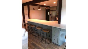 A modern kitchen with a bar area, wooden stools, and a built-in refrigerator. - Hop/Skip/Jump to Canyon Lake - 3 BR, 2 Bath (Canyon Lake)