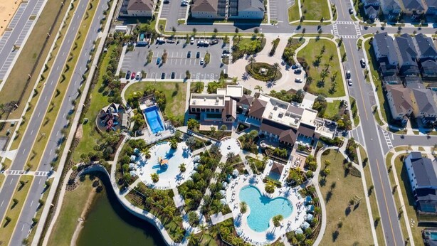 Ovenfra ses et resort med flere swimmingpools, en central bygning og omkringliggende veje.