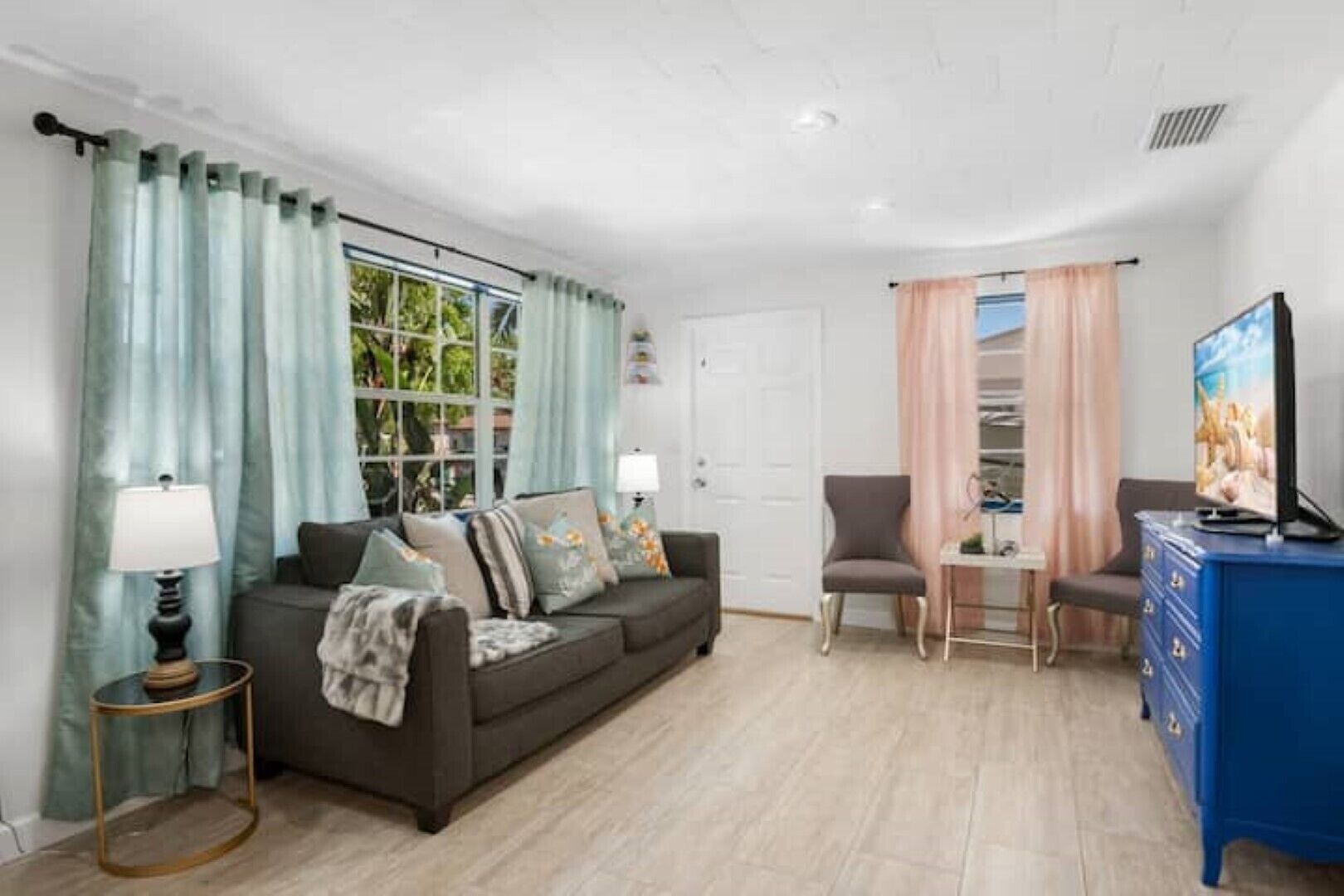 A living room with a sofa, a chair, a TV, and a small table.