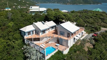 Relax in a spacious villa surrounded by lush greenery and enjoy scenic sea views from the large windows.
