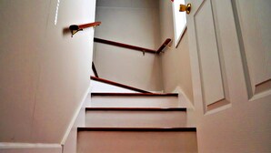 A staircase with wooden handrails and white walls. - The Wright Place (Kingsport)