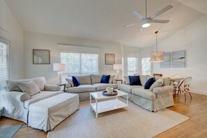 Relax in this stylish living room with a large L-shaped sofa, coffee table, and dining area.