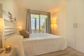 Relax in a serene space with a large bed, nightstand, and wardrobe.