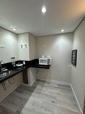 A modern kitchen with a black countertop, a built-in microwave, and a sink.