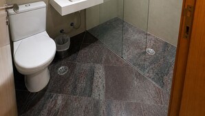 A modern bathroom with a toilet, sink, and glass shower enclosure. - Cozy apartment with modern design - Sol Alphaville Hotel & Residence (Barueri)
