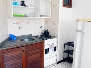 Réfrigérateur, un four, vaisselle et ustensiles, table de salle à manger