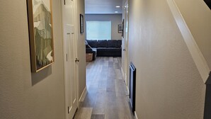 Ein Flur mit Holzboden, weißen Wänden und einer Deckenleuchte.
