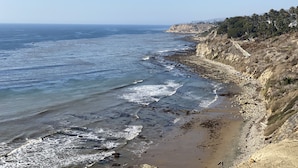 A coastal landscape with a rocky beach, clear sky, and distant hills. - LA Harbor View with Private Rooftop and FREE Tesla Charger (San Pedro)