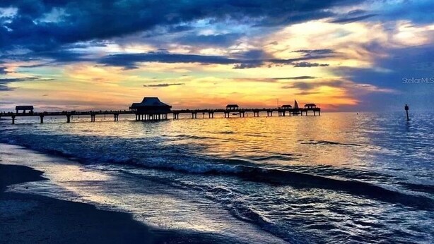 A pier extending into a body of water with a sunset in the background. - Updated condo just steps to the white sand beaches of Clearwater Beach (Clearwater)