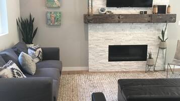 Een smart-tv, een open haard, boeken en een filmbibliotheek