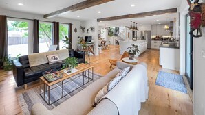 Un amplio espacio de sala con un sofá, una mesa de centro y un comedor con sillas y una mesa.