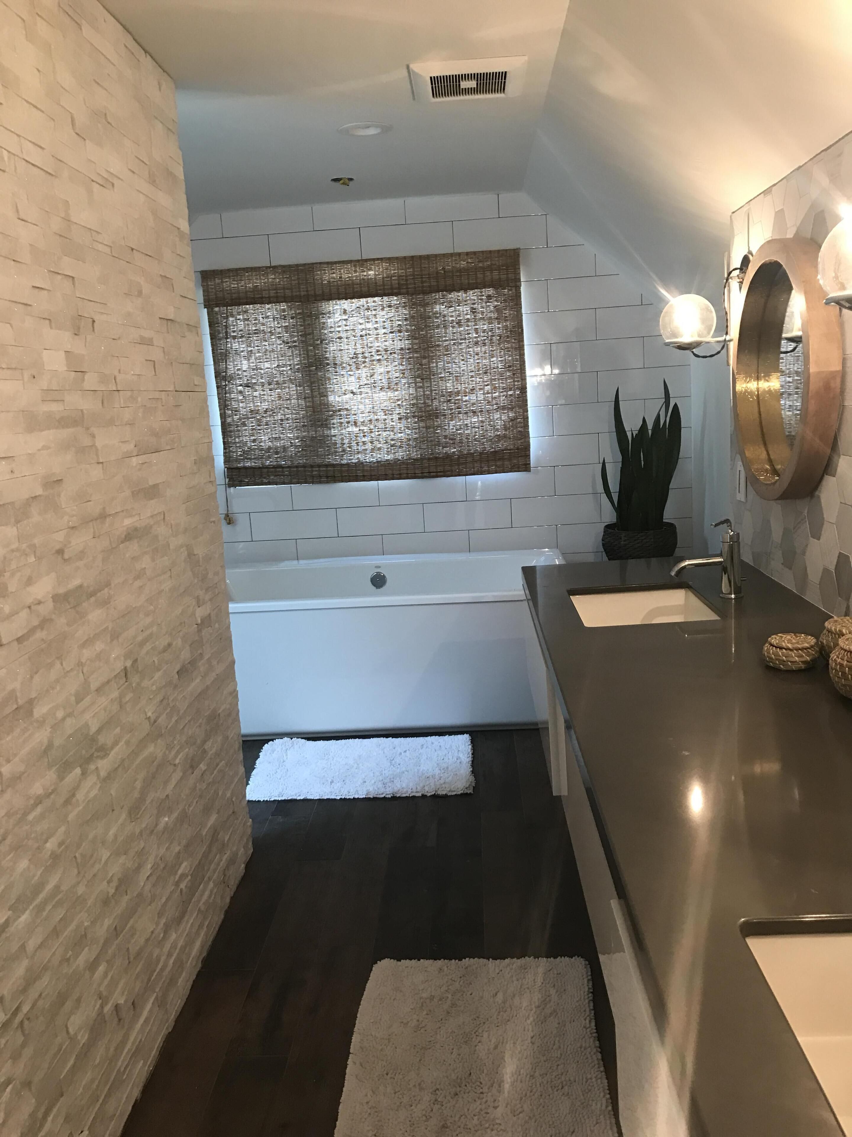 Een bad/douchecombinatie, een haardroger, handdoeken, zeep