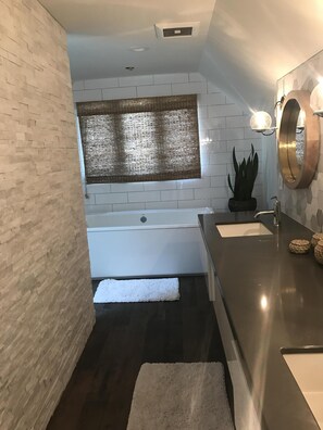 Een bad/douchecombinatie, een haardroger, handdoeken, zeep