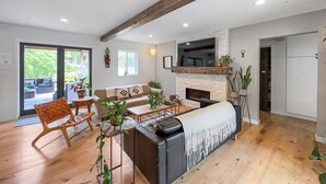 Una sala de estar moderna con chimenea, sofá y suelo de madera.