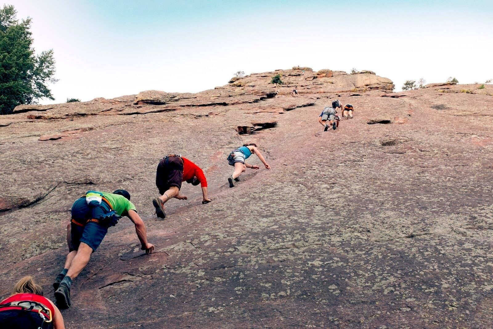 A group of people climbing a rocky hill.