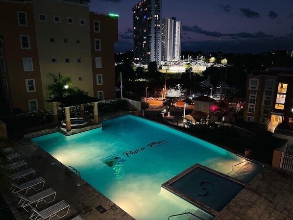 A swimming pool with a view of a high-rise building and other buildings in the background.
