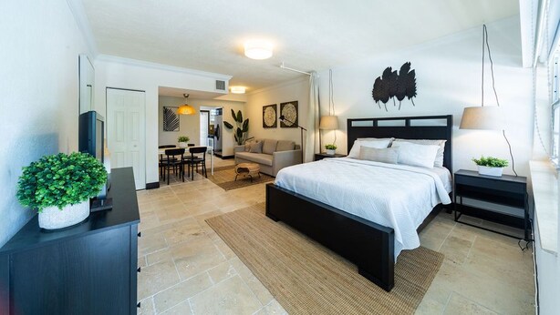 Une chambre moderne avec un grand lit, un bureau et un coin repas.