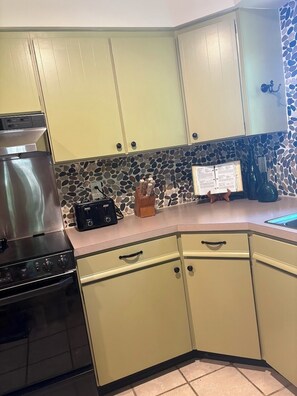 A kitchen with a stove, oven, and a stone backsplash.