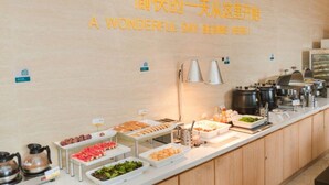 Un buffet proposant une variété de plats, et une pancarte sur le mur qui indique : « C’EST ICI QUE COMMENCE UNE JOURNÉE MAGNIFIQUE ! ».
