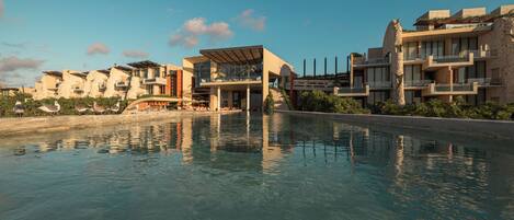 Un resort moderno con piscina, edificios de varios pisos y un cielo despejado.