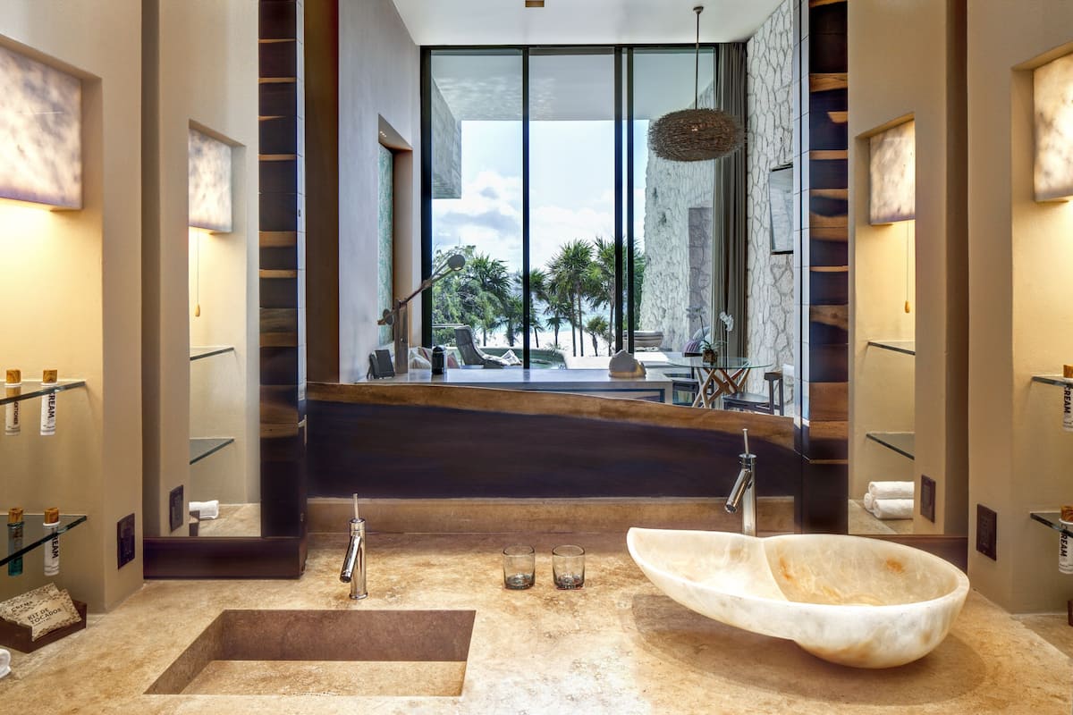 A modern bathroom with a large bathtub, a sink, and a glass shower enclosure.