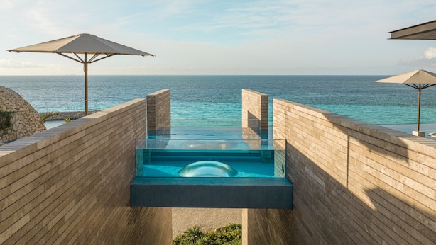 A modern infinity pool with a clear view of the ocean, wooden deck, and two umbrellas. - La Casa de la Playa by Xcaret-All Inclusive, Adults Only (Playa del Carmen)