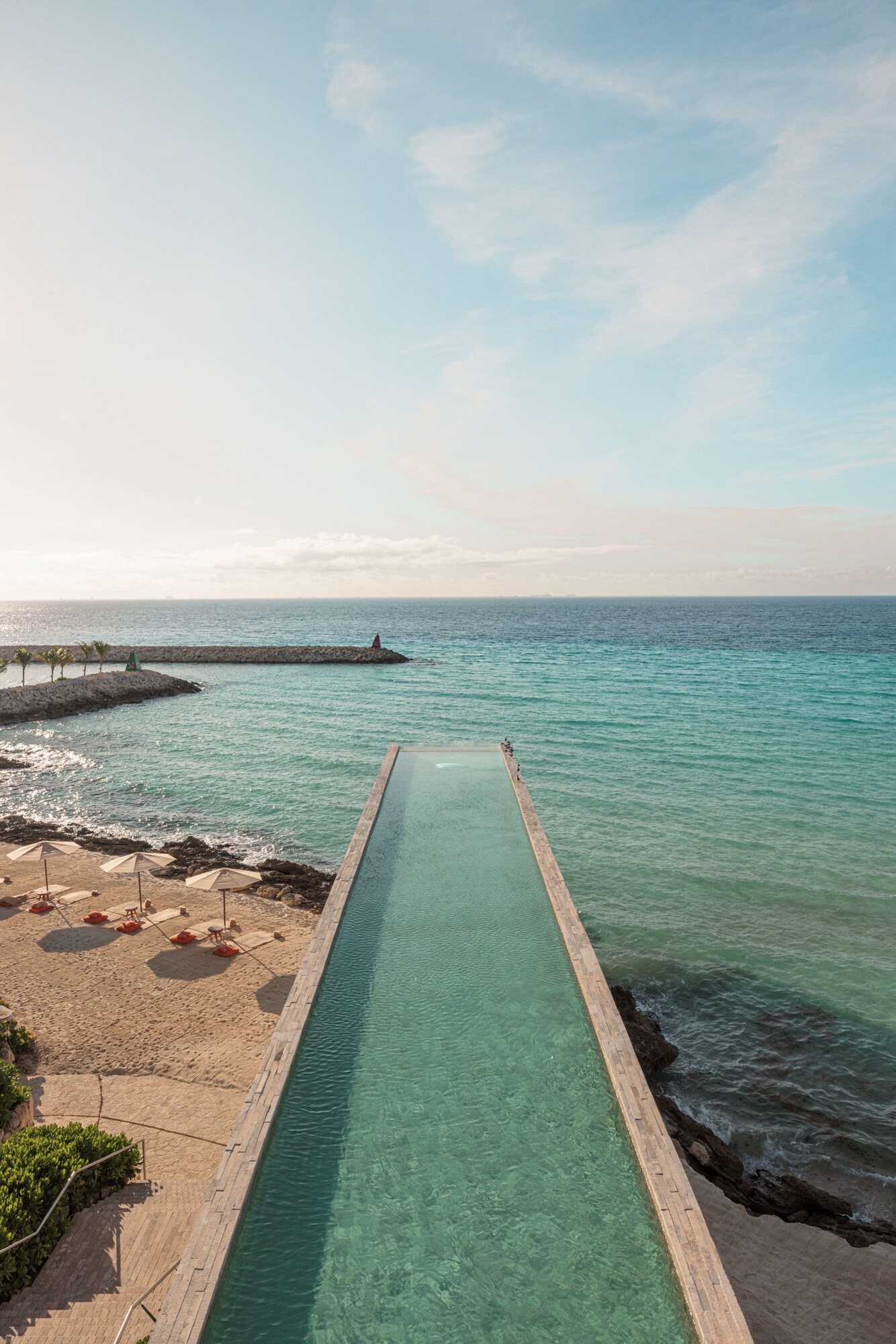 Alberca al aire libre, sombrillas en la alberca y camastros