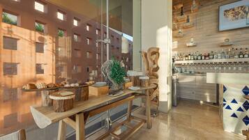 Una cocina moderna con encimeras de madera, una zona de bar con botellas y vistas a un edificio con amplios ventanales.