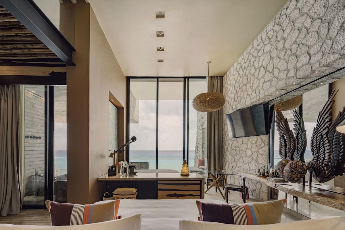 A modern room with a large window, a dining area, and a TV.