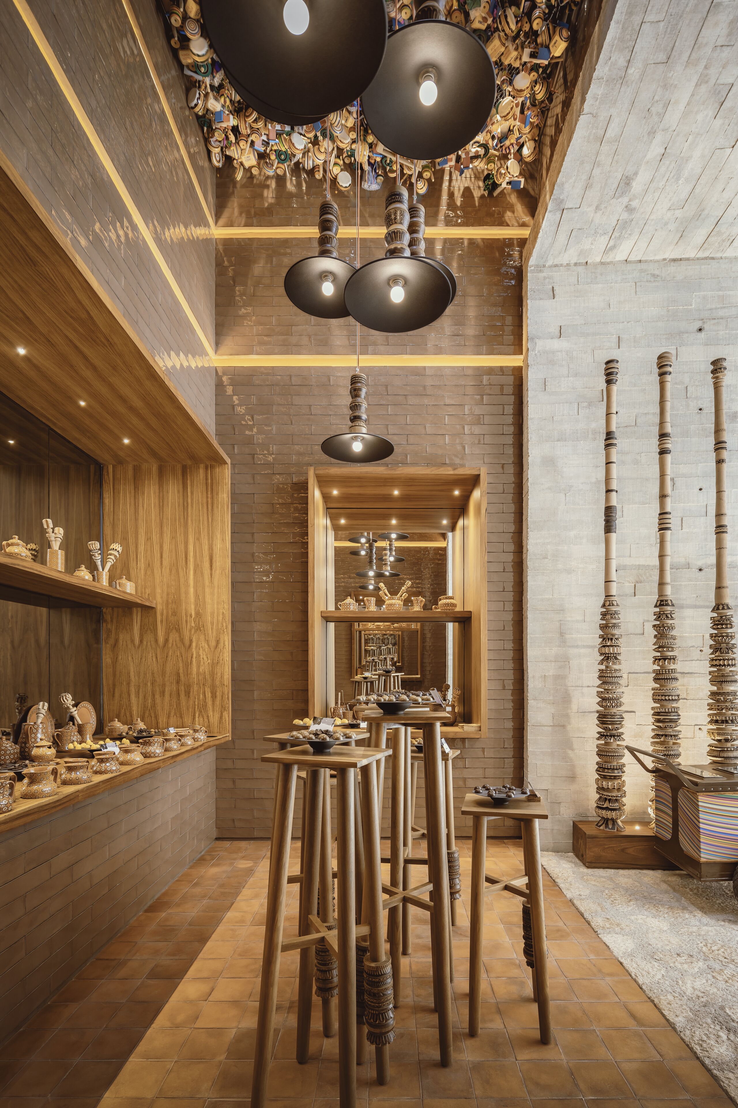 Interior de restaurante con decoración de madera, luces colgantes y pared de ladrillo.