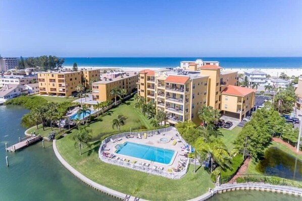 A resort with a pool, beachfront view, and multiple buildings.