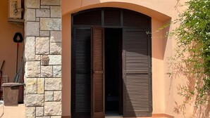 Entrada de un edificio con un muro de piedra y una puerta de madera.