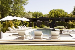 Una piscina al aire libre, sombrillas, tumbonas