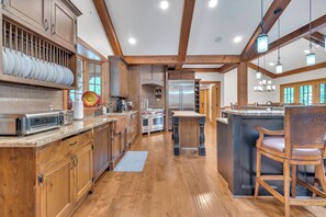 A spacious kitchen with wooden cabinets, a built-in oven, and a large island with seating.