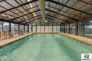 Relax by the pool surrounded by comfortable deck chairs and a small table.