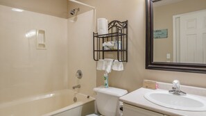Une salle de bain équipée d’une baignoire, de toilettes, d’un lavabo et d’un porte-serviettes avec des serviettes.