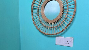 Un baño con un lavamanos blanco, un espejo y un interruptor de luz en la pared.