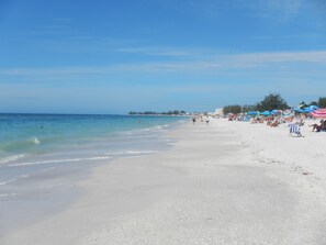 A beach with a sandy shore, umbrellas, and people. - 🌴Palms Heaven Villa•  2BR/2BA/2 Pools & Heated Hot Tubs •Near IMG / Beaches (Bradenton)