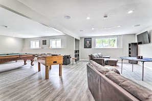 Amplia sala de estar con mesa de billar, mesa de fútbol de mesa y una zona de estar confortable.
