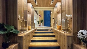 Una escalera de madera con puertas de vidrio que dan a un cuarto con una pared azul.